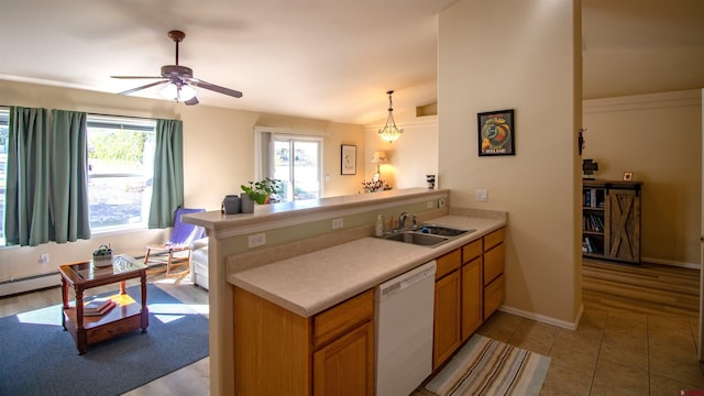 kitchen with light countertops, ceiling fan, dishwasher, a sink, and a peninsula