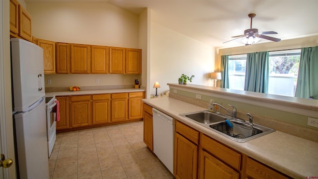 kitchen featuring light countertops, a sink, lofted ceiling, and white appliances