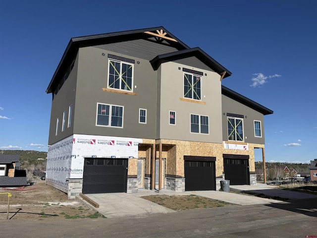 125 Salt Brush St Unit 502, Durango, CO 81301 - view of front of home with a garage, stucco siding, stone siding, and concrete driveway