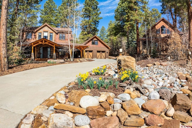 log home featuring a garage, aphalt driveway, and covered porch