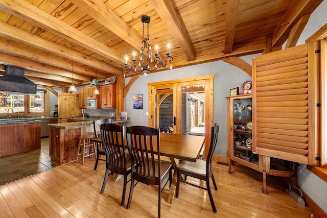 dining space with wood ceiling, light wood-style floors, a notable chandelier, and arched walkways