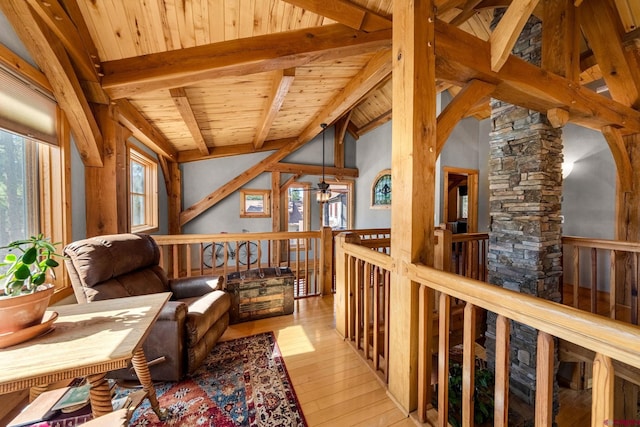 interior space with lofted ceiling with beams, wood ceiling, an upstairs landing, wood-type flooring, and a ceiling fan