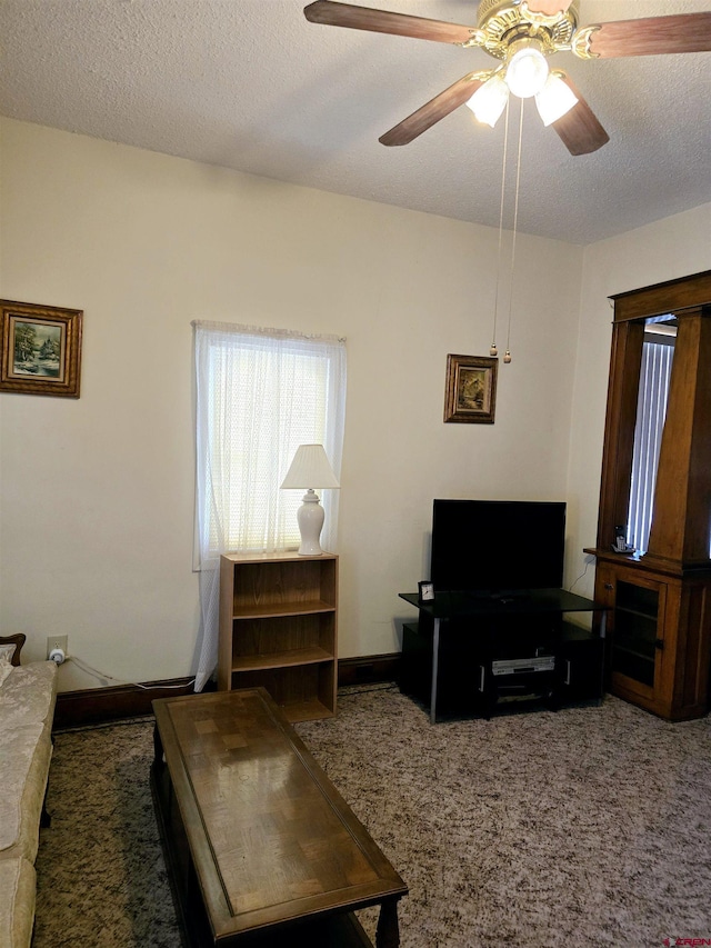 carpeted living area featuring a textured ceiling, a ceiling fan, and baseboards