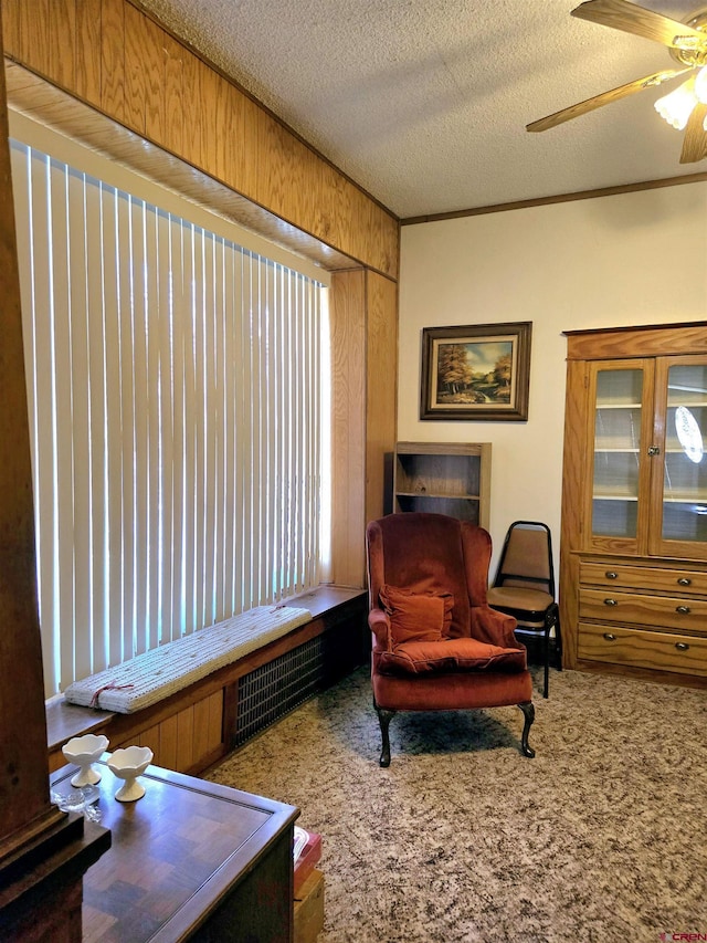 sitting room featuring a textured ceiling, a ceiling fan, and carpet floors