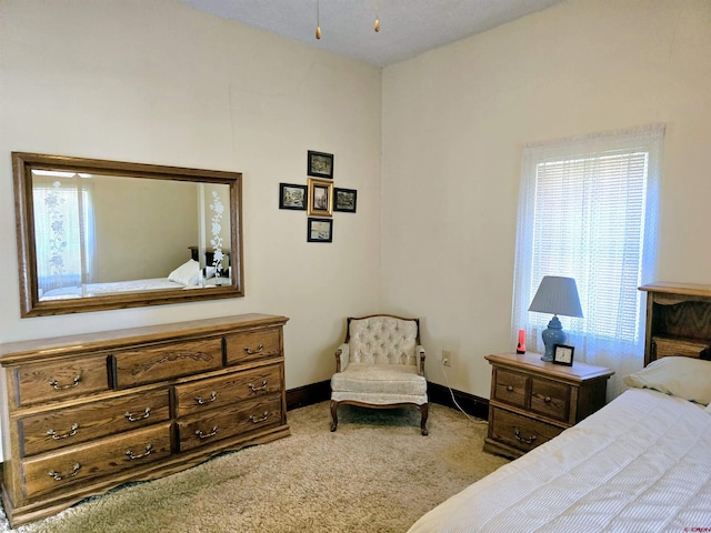 bedroom featuring baseboards and carpet
