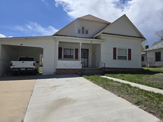 view of front of home with concrete driveway and an attached carport