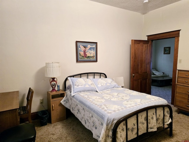 bedroom with a textured ceiling and carpet floors