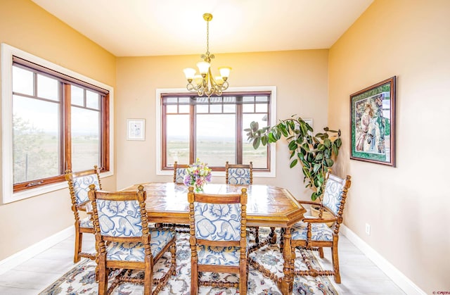 dining area with baseboards, a chandelier, and a healthy amount of sunlight