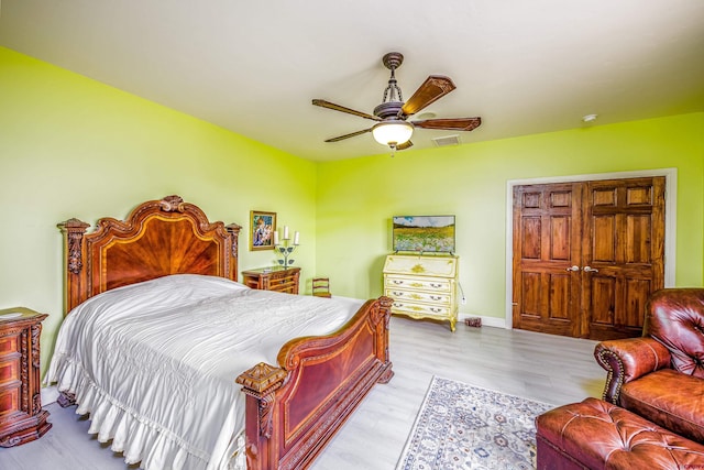 bedroom with visible vents, baseboards, ceiling fan, and wood finished floors