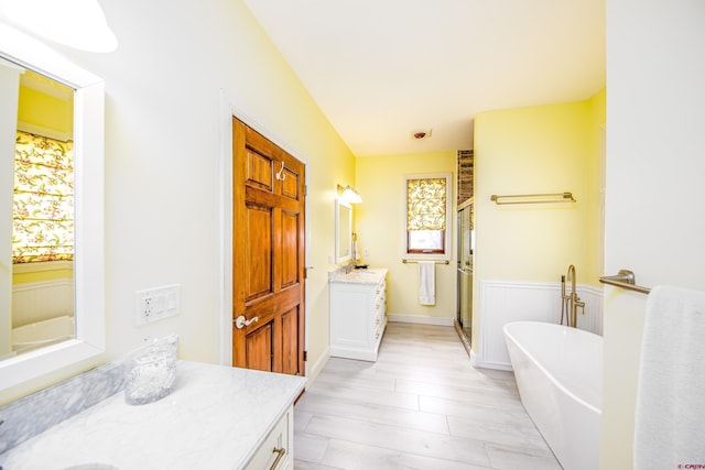 full bath featuring vanity, a soaking tub, and a shower stall