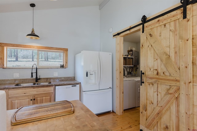85 Mclain Ct, Pagosa Springs, CO 81147 - kitchen with light brown cabinets, white appliances, light wood-type flooring, a barn door, and a sink