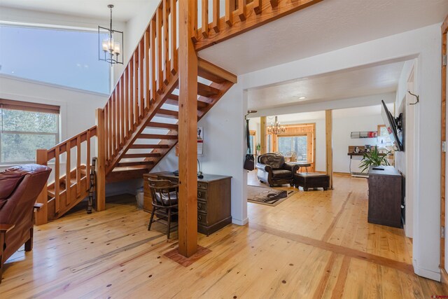 85 Mclain Ct, Pagosa Springs, CO 81147 - staircase with an inviting chandelier, a healthy amount of sunlight, and hardwood / wood-style flooring