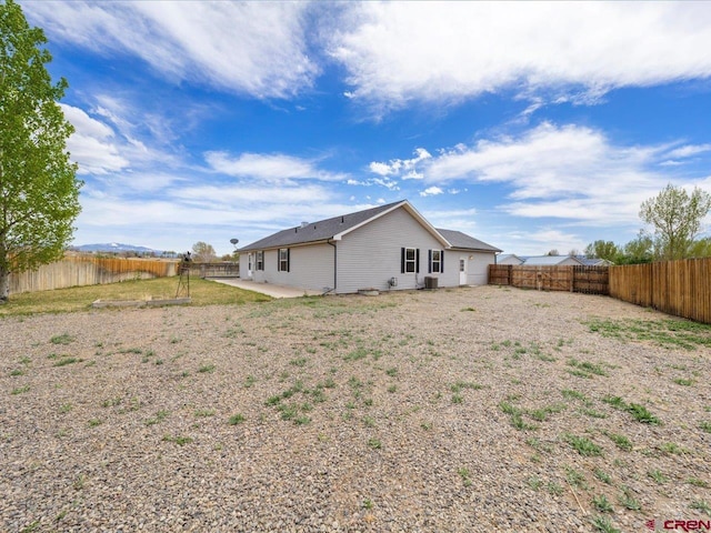 back of property with a fenced backyard and a patio area