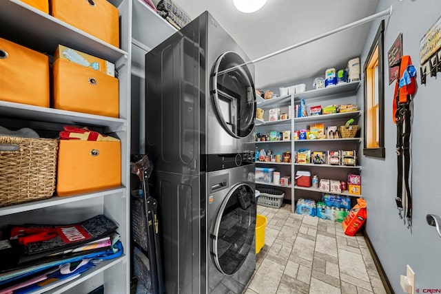 laundry room featuring stacked washer / drying machine and laundry area