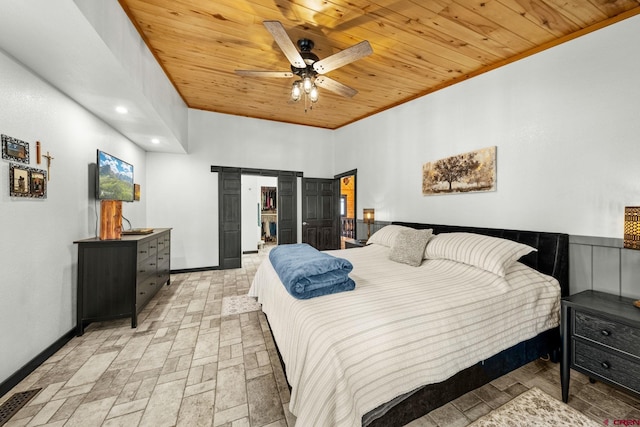 bedroom with a barn door, brick floor, a ceiling fan, baseboards, and wood ceiling