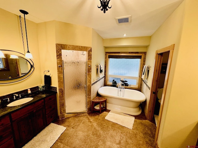bathroom featuring visible vents, a wainscoted wall, a freestanding bath, and vanity