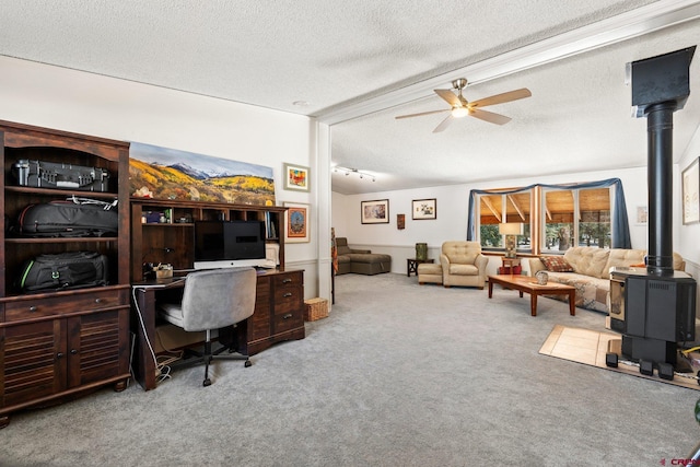 office featuring carpet floors, a ceiling fan, a textured ceiling, and a wood stove