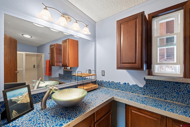 full bathroom featuring vanity, a textured ceiling, and a shower stall