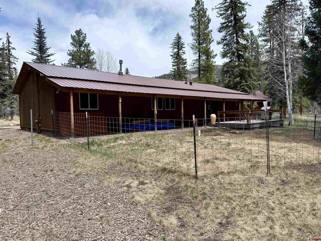back of property with an exterior structure, metal roof, and an outdoor structure