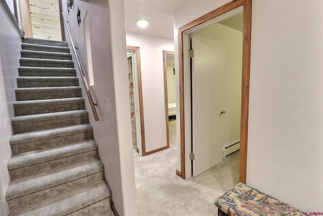 stairway featuring a baseboard radiator and carpet flooring