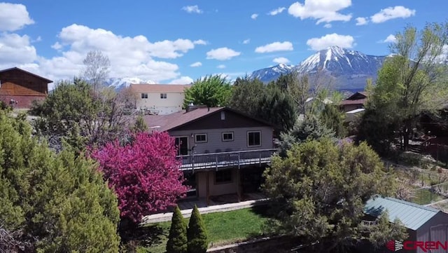 rear view of house featuring a deck with mountain view