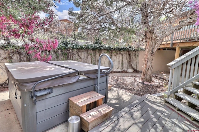 view of patio with stairs, a hot tub, fence, and a deck