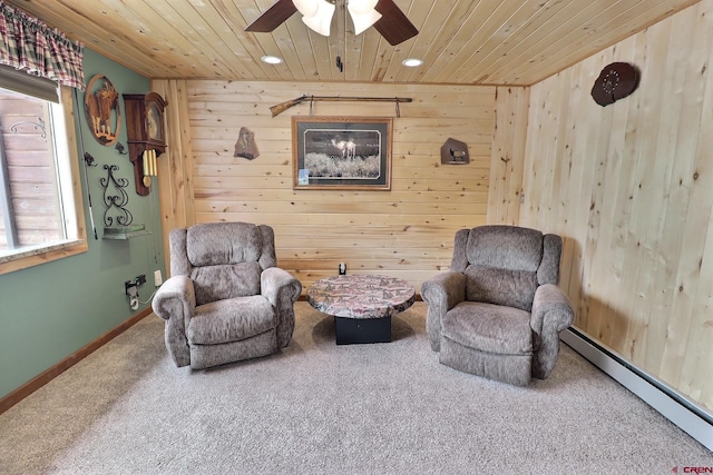 living area featuring wooden walls, wood ceiling, a baseboard heating unit, and carpet floors