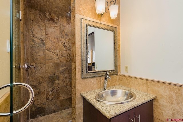 bathroom featuring tile walls, a shower stall, and vanity