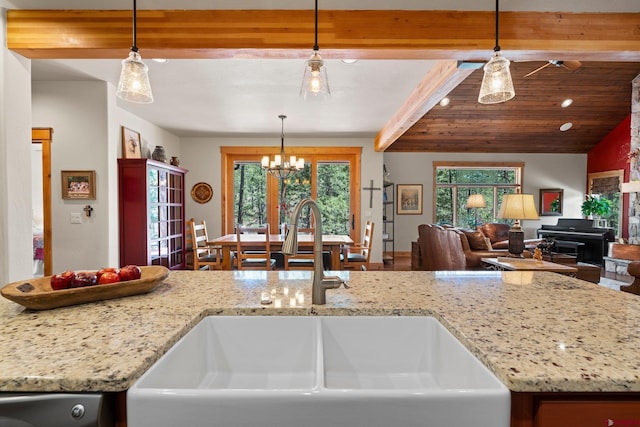 300 Copper Rim Trl, Durango, CO 81301 - kitchen featuring an inviting chandelier, beamed ceiling, open floor plan, light stone counters, and a sink