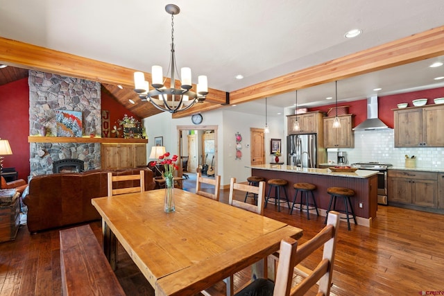 300 Copper Rim Trl, Durango, CO 81301 - dining area featuring dark wood-style flooring, lofted ceiling with beams, an inviting chandelier, and a stone fireplace