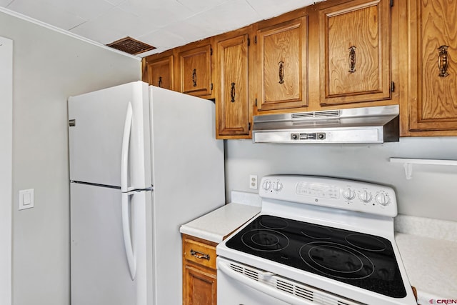 kitchen with visible vents, white appliances, light countertops, under cabinet range hood, and brown cabinets