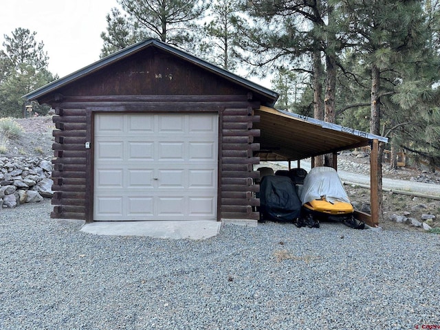 garage featuring a garage and gravel driveway