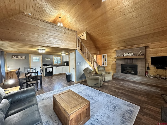 living area featuring wood ceiling, a fireplace with raised hearth, vaulted ceiling, and stairs