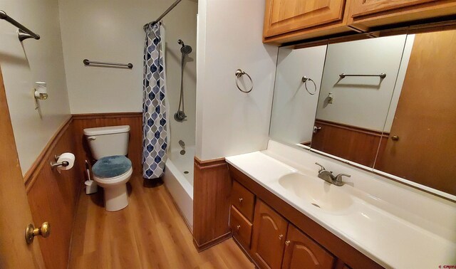 108 N 15th St, Dolores, CO 81323 - bathroom featuring wainscoting, vanity, toilet, wood finished floors, and shower / tub combo