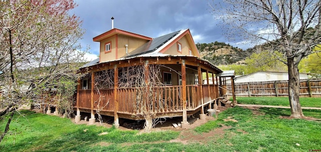 108 N 15th St, Dolores, CO 81323 - rear view of house with fence, a yard, a wooden deck, and metal roof