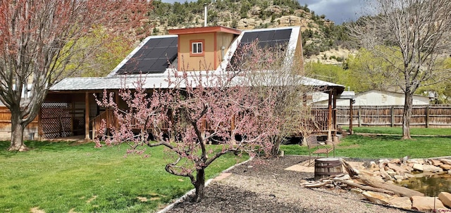 108 N 15th St, Dolores, CO 81323 - rear view of house featuring a fire pit, fence, a yard, and metal roof