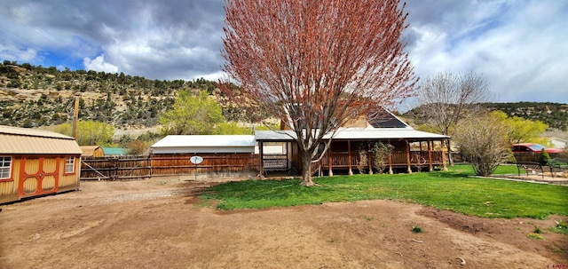 108 N 15th St, Dolores, CO 81323 - back of house with an outbuilding, fence, a yard, and a storage shed