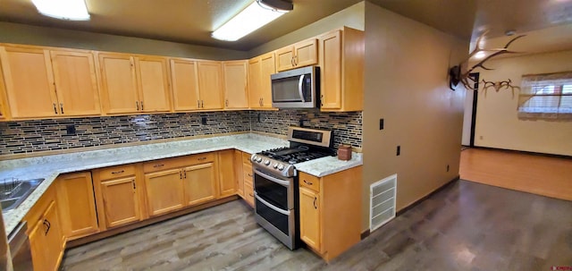 108 N 15th St, Dolores, CO 81323 - kitchen with light wood-style floors, light brown cabinets, stainless steel appliances, decorative backsplash, and visible vents