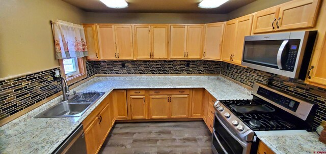 108 N 15th St, Dolores, CO 81323 - kitchen with light brown cabinets, tasteful backsplash, a sink, light wood-style flooring, and appliances with stainless steel finishes