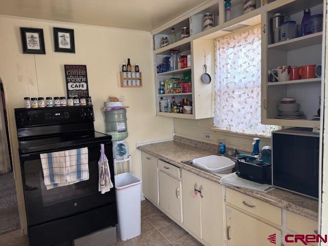 kitchen featuring open shelves, white cabinetry, black electric range, a sink, and light tile patterned floors