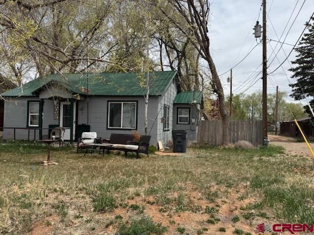 back of house with fence and metal roof