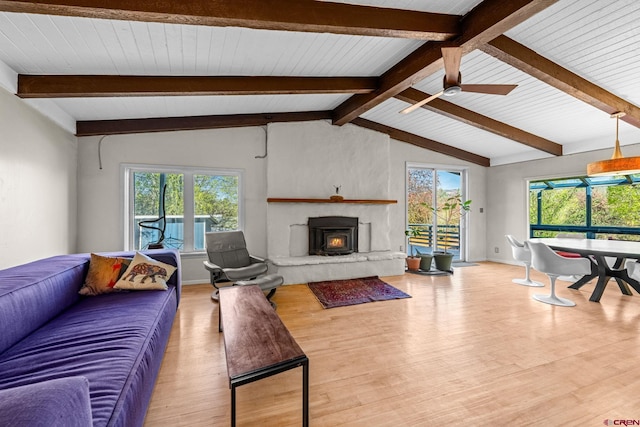 living area featuring a ceiling fan, lofted ceiling with beams, plenty of natural light, and wood finished floors