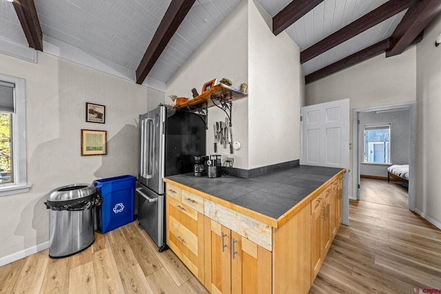 kitchen featuring vaulted ceiling with beams, tile countertops, and plenty of natural light