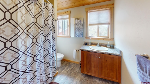 full bath featuring a shower with curtain, wood finished floors, vanity, baseboards, and toilet
