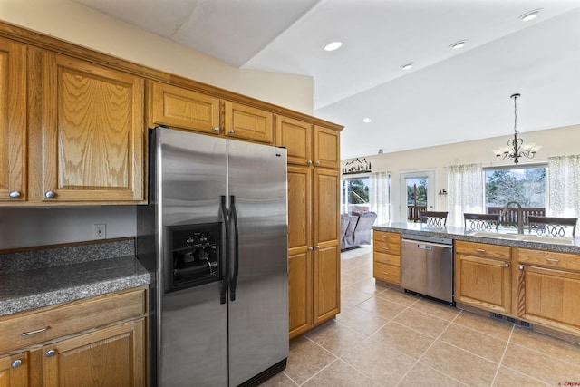 kitchen featuring brown cabinetry, visible vents, a chandelier, light tile patterned floors, and stainless steel appliances