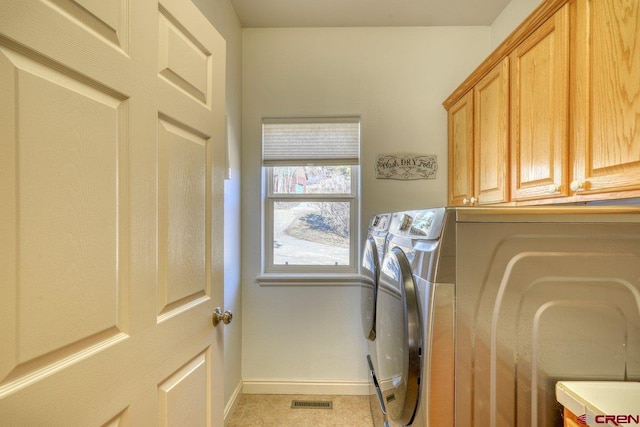 laundry area featuring baseboards, cabinet space, washer and dryer, and visible vents
