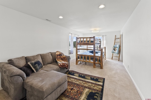 living area featuring visible vents, recessed lighting, baseboards, and light carpet