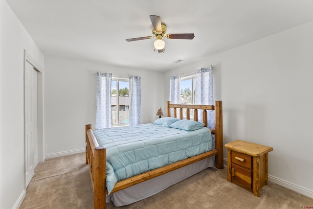 bedroom with baseboards, visible vents, light carpet, and ceiling fan