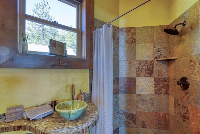 full bath with vanity and a tile shower