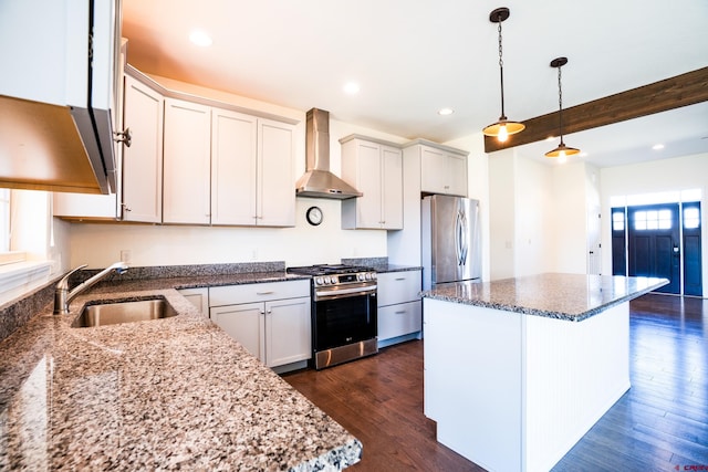1010 N 11th St, Gunnison, CO 81230 - kitchen featuring appliances with stainless steel finishes, a sink, wall chimney exhaust hood, a center island, and dark wood-type flooring